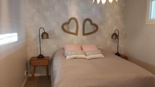 a bedroom with a bed with two pillows and two lamps at Kanervikko in Kalajoki