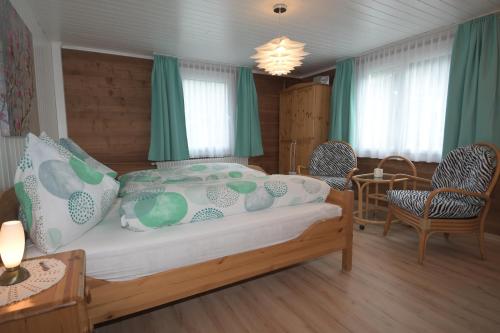 a bedroom with a bed and two chairs and a table at Haus Wiedersehen, Weissmies (3-Zi) in Saas-Grund