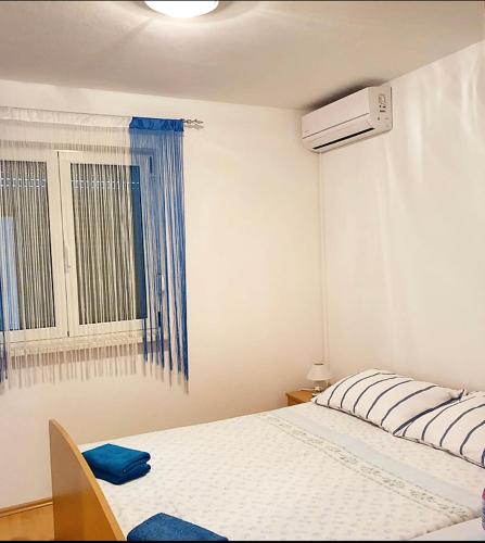 a bedroom with a white bed and a window at Guesthouse Pejo in Poreč