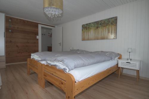 ein Schlafzimmer mit einem großen Bett mit einem Holzrahmen in der Unterkunft Haus Wiedersehen, Mischabel (2-Zi) in Saas-Grund