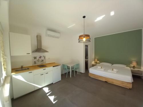 1 dormitorio con cama, mesa y cocina en AMARE MATERA comfortable rooms, en Matera
