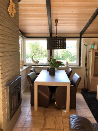 ein Esszimmer mit einem Tisch und einem Kamin in der Unterkunft vakantiehuisje Gerolstein in Gerolstein