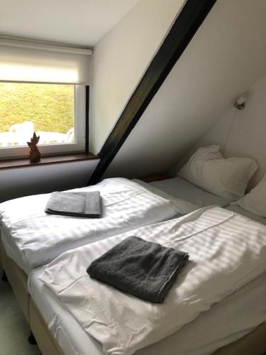 1 Schlafzimmer mit 2 Betten mit weißer Bettwäsche und einem Fenster in der Unterkunft vakantiehuisje Gerolstein in Gerolstein