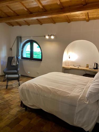 a bedroom with a large bed and a chair at Relais FraSimon Antico Casale in San Vito Chietino