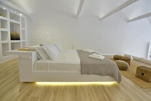 ein weißes Schlafzimmer mit einem Bett und einem Schreibtisch in der Unterkunft Hydra Hospitality Port Apartment in Hydra