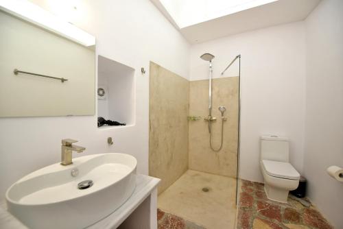 a bathroom with a sink and a shower and a toilet at Hydra Hospitality Port Apartment in Hydra