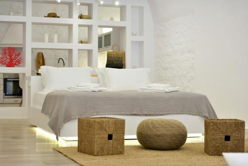 a white bedroom with a bed with two ottomans at Hydra Hospitality Port Apartment in Hydra