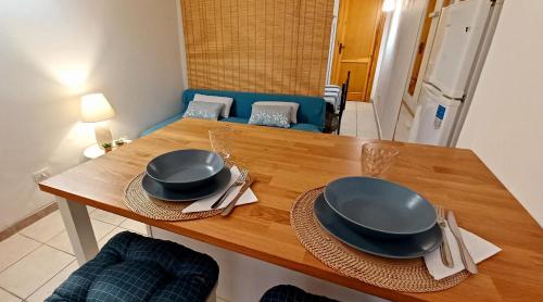 una mesa de madera con dos platos encima en Casa di Zio en Alguer