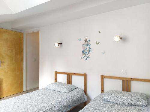 2 camas en una habitación con paredes blancas en Baiona Sainte Cath -5 BOST- au cœur de Saint Esprit, en Bayona