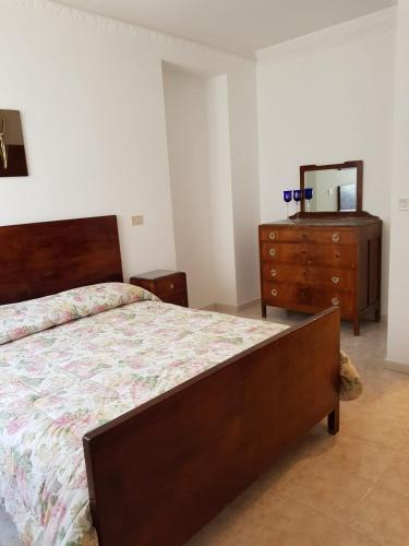 1 dormitorio con cama, tocador y espejo en Holiday House a Firmo, en Firmo