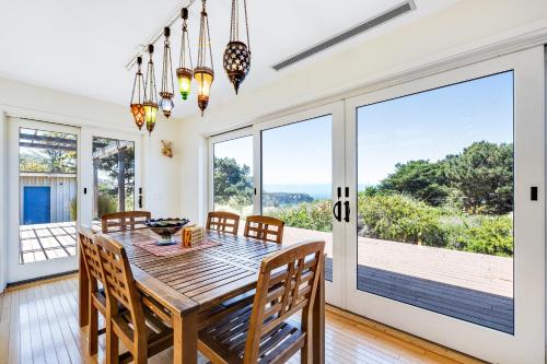 a dining room with a table and chairs and sliding glass doors at Voyagers Paradise in Gualala