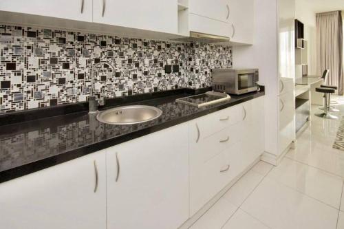 a kitchen with a sink and a microwave at Luxury studio in Sport City in Dubai
