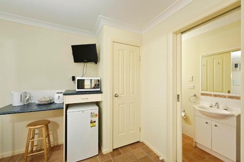 a small kitchen with a white refrigerator and a sink at Mudgee Valley Park in Mudgee