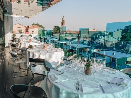 un gruppo di tavoli e sedie con tovaglie bianche di Hotel Continental a Cremona