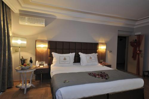 a hotel room with a large bed and a table at Grand Atakum Hotel in Samsun