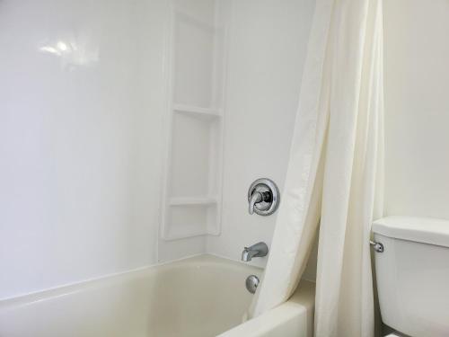 a bathroom with a white tub and a toilet at Wiarton Willys Inn in Wiarton