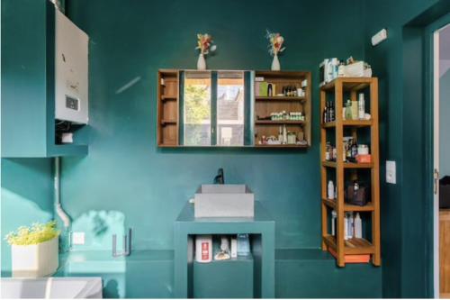 um quarto com uma parede azul com uma estante de livros em Charmante chambre double chez l'habitant em Pantin