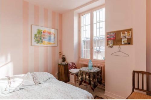 a bedroom with a bed and a table and a window at Charmante chambre double chez l'habitant in Pantin