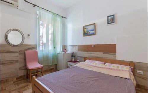 a bedroom with a bed and a pink chair at Two Room Eva in Pula