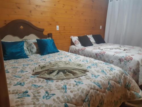 two beds sitting next to each other in a bedroom at Casa família bonfim in Urubici