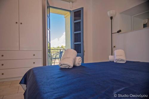 um quarto com uma cama azul e uma varanda em Studio Gerani 2 em Porto Heli