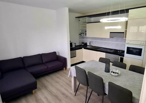 a living room with a couch and a table with chairs at NAT Apartments in Koper