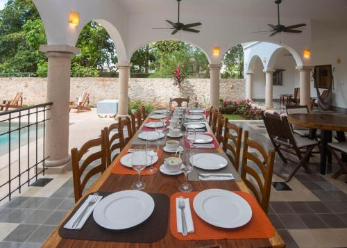 a long wooden table with plates and napkins on it at Hotel Posada San Juan in Valladolid
