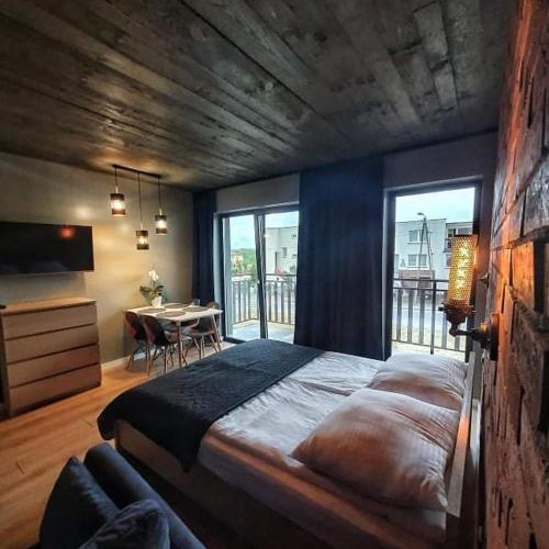 a large bedroom with a large bed and a table at Loft 66 Apartamenty in Władysławowo