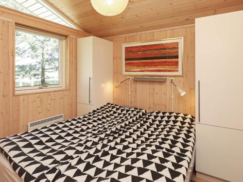 ロービュにあるHoliday home Rødby XIのベッドルーム1室(ベッド1台に白黒の掛け布団付)