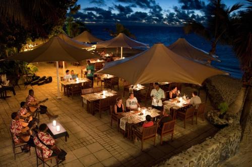 a group of people sitting at tables in a restaurant at Castaway Island, Fiji in Castaway Island