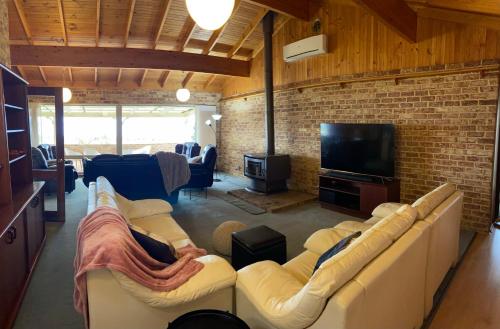 a living room with couches and a brick wall at Sunrise House in Albany
