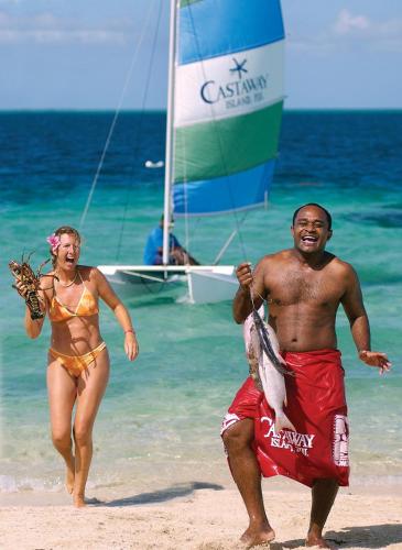 a man and a woman running on the beach at Castaway Island, Fiji in Castaway Island