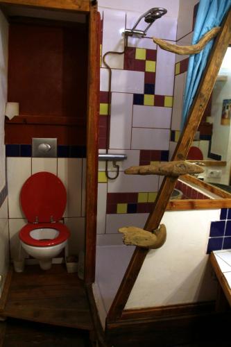 a bathroom with a red toilet in a room at La Paille in Pelvoux