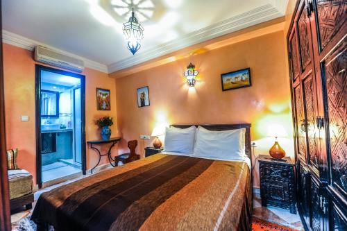 マラケシュにあるRiad Errabii & Spaのベッドルーム1室(オレンジ色の壁の大型ベッド1台付)