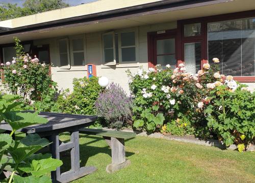 a bench sitting in the grass in front of a house at Dunstan House in Clyde