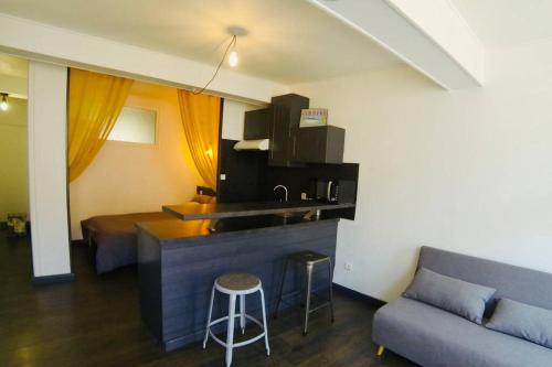 - une cuisine et un salon avec un canapé et un bar dans l'établissement Grand studio à deux pas du Vieux Port, à La Rochelle
