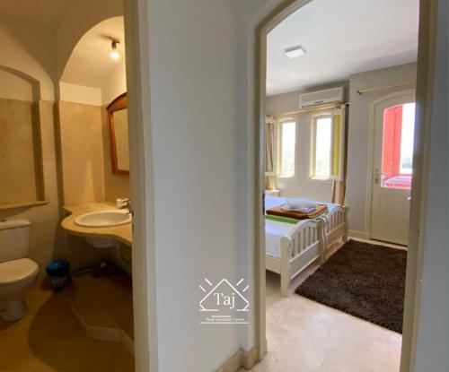 y baño con cama, lavabo y aseo. en Taj Home, Amazing pool and lagoon view 2bedrooms apartment, en Hurghada