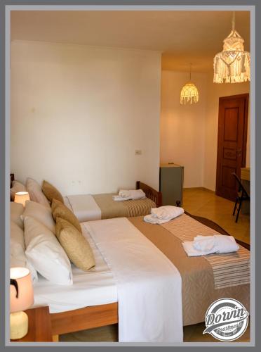 two beds in a hotel room with pillows on them at Dorvin Apartments in Dhërmi