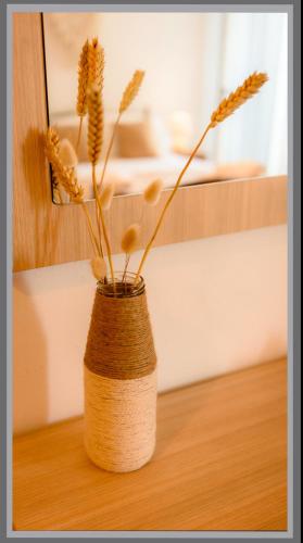 a vase with flowers in it sitting on a table at Dorvin Apartments in Dhërmi