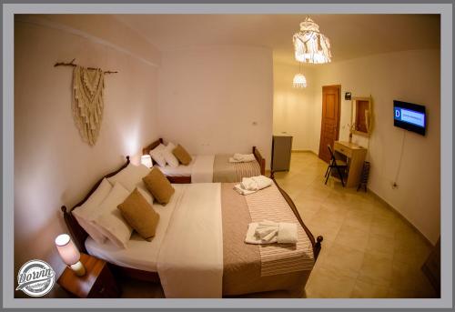 a hotel room with two beds and a bathroom at Dorvin Apartments in Dhërmi
