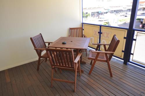 una mesa de madera y sillas en una terraza con vistas al puerto en The Australian Hotel Motel, en Dalby