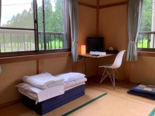 a bedroom with a bed and a desk and windows at Makino Kogen 123 Building - Vacation STAY 83784 in Kaizu