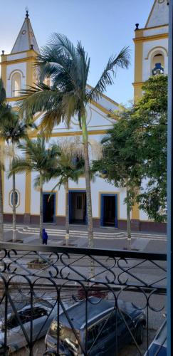 a yellow building with palm trees in front of it at Vila de Cunha in Cunha