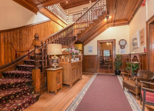 an ornate staircase in a living room with wood paneling at Dunstan House in Clyde