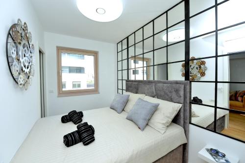 1 dormitorio con 1 cama con almohadas blancas y negras en Exclusive Residence Apartment, en Zadar