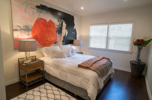 - une chambre avec un lit et une peinture murale dans l'établissement Cozy Suite near Universal Studios, à Los Angeles