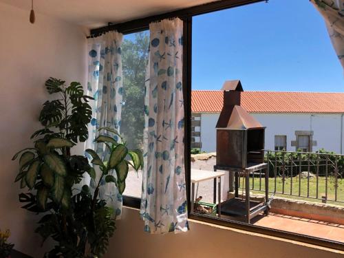 ventana con cortinas y estufa en una habitación en Las Canchillas en La Carrera
