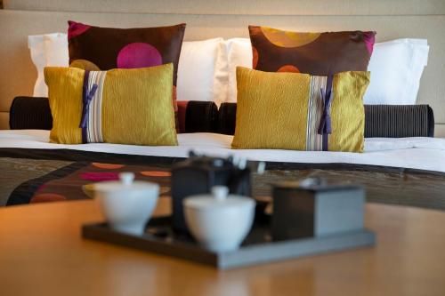 a bed with pillows and a table in a room at Hotel New Otani Tokyo EXECUTIVE HOUSE ZEN in Tokyo
