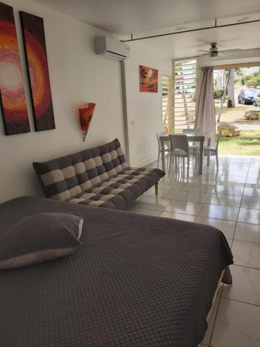 a bedroom with a bed and a table and chairs at ANSE DES ROCHERS St François CORAIL 306 in Saint-François