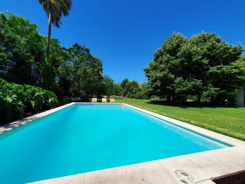 a blue swimming pool with trees in the background at La Diferencia in Chivilcoy
